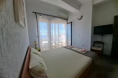 a bedroom with a large white bed with a window at Marko Apartments in Ulcinj