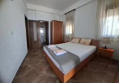 a bedroom with a large bed and a bathroom at Marko Apartments in Ulcinj