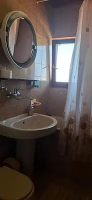 a bathroom with a sink and a toilet and a mirror at Marko Apartments in Ulcinj