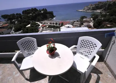 a table and chairs on a balcony with a view of the ocean at Marko Apartments in Ulcinj