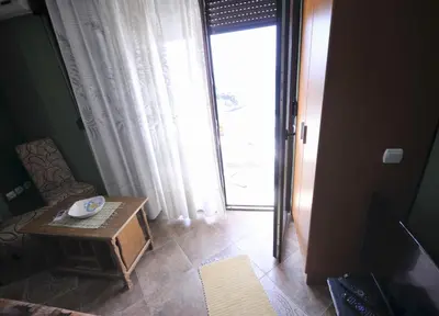 a room with a table and a door with a window at Marko Apartments in Ulcinj