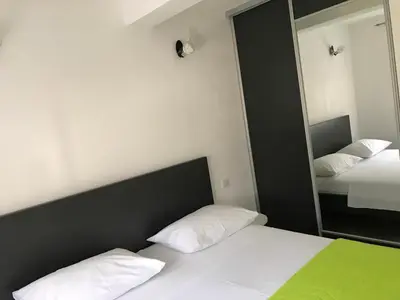 a bedroom with a bed and a large mirror at Apartment K2 in Radanovići