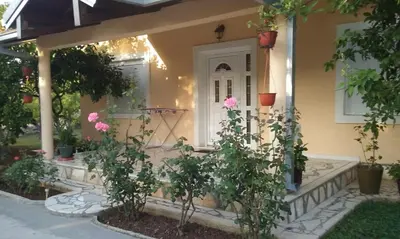 a front porch of a house with pink roses at Apartment K2 in Radanovići