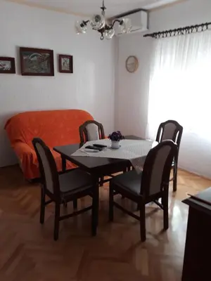 a dining room with a table and chairs and a bed at Apartment K2 in Radanovići