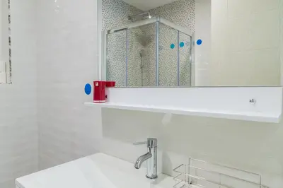 a white bathroom with a sink and a mirror at Apartment Blue Adriatic in Budva
