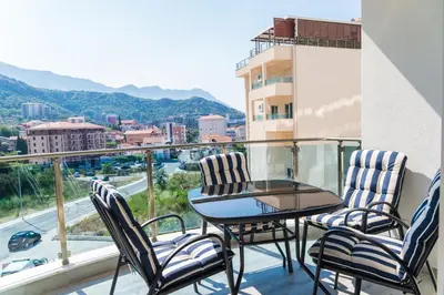 a balcony with a table and chairs and a view of a city at Apartment Blue Adriatic in Budva