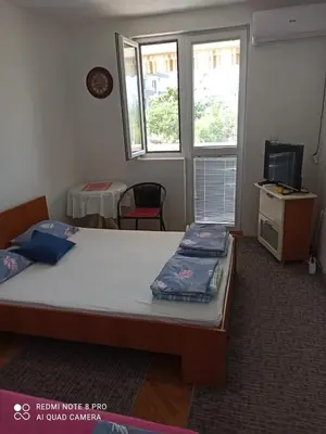 a bedroom with two beds and a desk and two windows at Anika apart in Bar