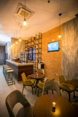 a restaurant with tables and chairs and a brick wall at Hotel Ulliri & SPA in Ulcinj
