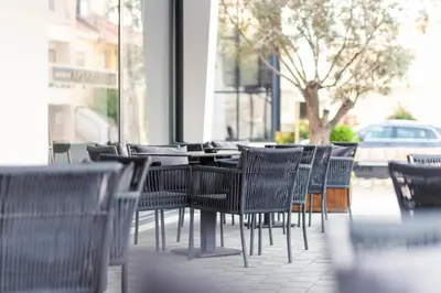 a row of chairs and tables in a restaurant at Hotel Ulliri & SPA in Ulcinj