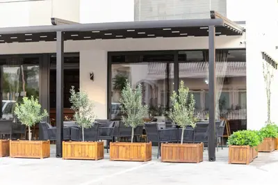 a group of potted plants in front of a building at Hotel Ulliri & SPA in Ulcinj