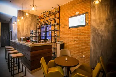 a restaurant with tables and chairs and a brick wall at Hotel Ulliri & SPA in Ulcinj