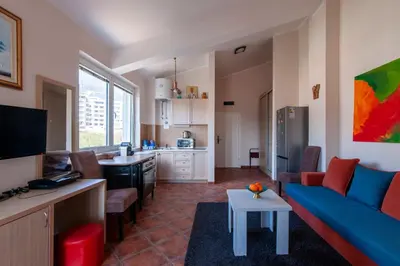 a living room with a blue couch and a kitchen at Lux M & A Apartments in Budva