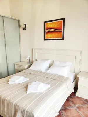 a bedroom with a large bed with white sheets at Lux M & A Apartments in Budva