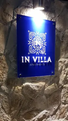 a blue sign on the wall of a building at IN Villa Guesthouse in Sutomore