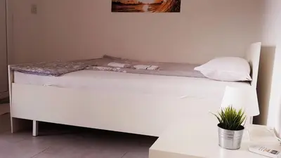 a white bed in a room with a table at IN Villa Guesthouse in Sutomore