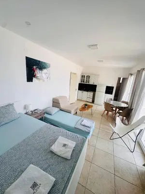 a room with two beds and a living room at IN Villa Guesthouse in Sutomore
