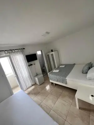 a bedroom with a bed and a large window at IN Villa Guesthouse in Sutomore