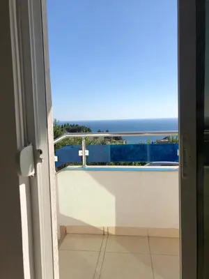 a door to a balcony with a view of the ocean at Apartmani Dini in Ulcinj