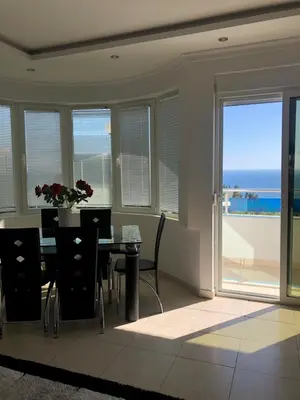 a dining room with a table and a view of the ocean at Apartmani Dini in Ulcinj