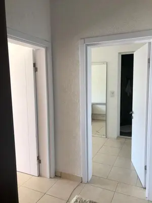 an empty room with two doors and a bedroom at Apartmani Dini in Ulcinj