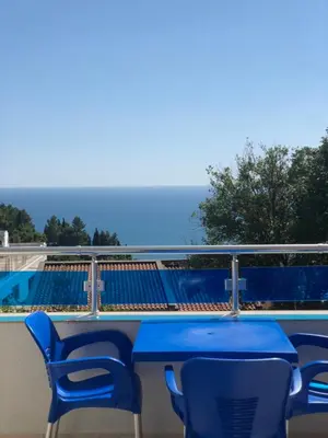 a blue table and chairs on a balcony with the ocean at Apartmani Dini in Ulcinj