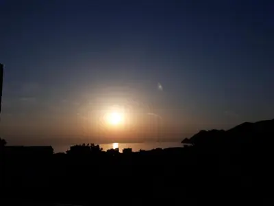 a sunset over the water with the sun in the sky at Apartmani RAR in Dobra Voda