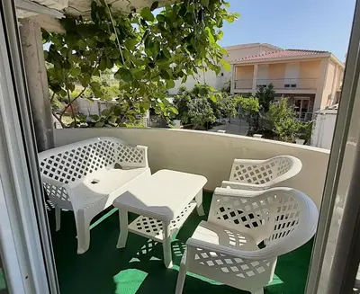 a white table and chairs on a balcony at Apartmani RAR in Dobra Voda