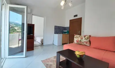 a living room with a orange couch and a table at Apartmani RAR in Dobra Voda