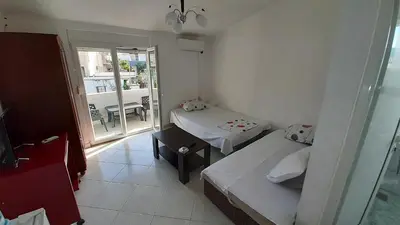 a small room with two beds and a balcony at Apartmani RAR in Dobra Voda