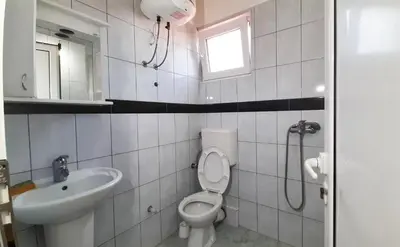 a bathroom with a toilet and a sink at Apartmani RAR in Dobra Voda