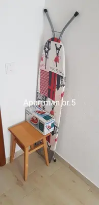 a chair with a table next to a wall at Apartmani Nikmil Bar- Šusanj in Bar