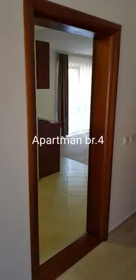 a glass door into a room with a mirror at Apartmani Nikmil Bar- Šusanj in Bar