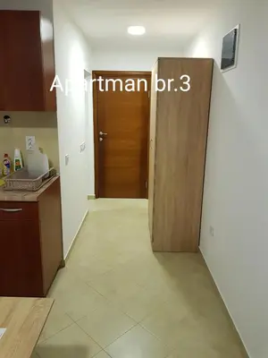 a room with a door and a kitchen with a floor at Apartmani Nikmil Bar- Šusanj in Bar