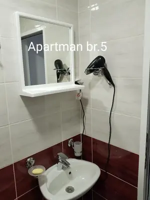 a bathroom with a sink and a mirror and a lamp at Apartmani Nikmil Bar- Šusanj in Bar