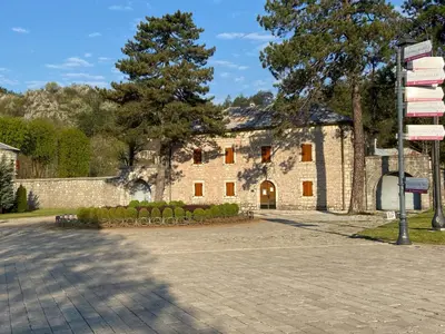 a large stone building with a street sign in front of it at Apartments Kapisoda in Cetinje