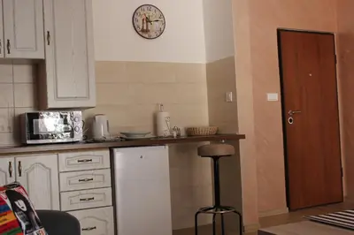 a kitchen with white cabinets and a counter with a stool at Apartments Kapisoda in Cetinje