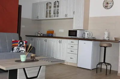 a kitchen with white cabinets and a table at Apartments Kapisoda in Cetinje