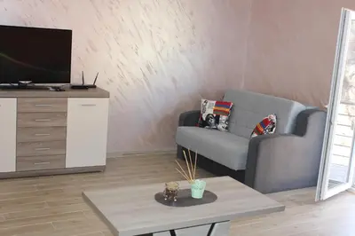 a living room with a couch and a tv at Apartments Kapisoda in Cetinje