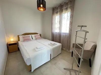 a bedroom with a white bed and a chair at OSA Holiday in Ulcinj