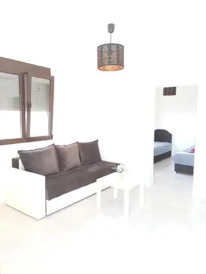 a white living room with a couch and a table at OSA Holiday in Ulcinj