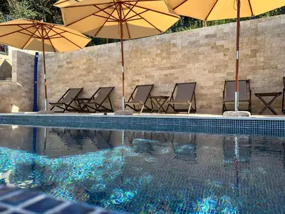 a group of chairs and umbrellas next to a swimming pool at Casa Bianca & Spa in Ulcinj