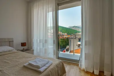 a bedroom with a bed and a large window at Apartments LORA Bokeljske brigade in Budva