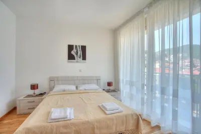 a bedroom with a bed and a large window at Apartments LORA Bokeljske brigade in Budva
