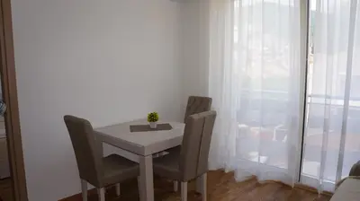 a small table and chairs in a room with a window at Apartments LORA Bokeljske brigade in Budva