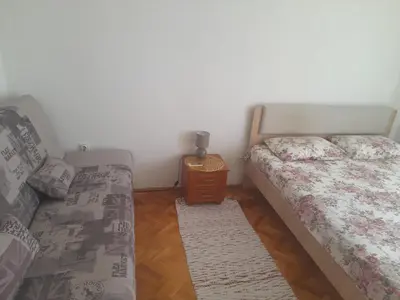 a bedroom with two beds and a table with a night stand at Tina Rooms in Ulcinj