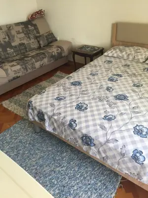 a bedroom with a bed with a quilt on it at Tina Rooms in Ulcinj