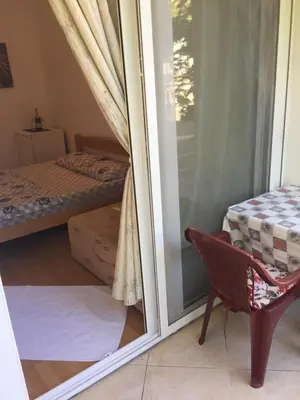 a room with a window and a bed and a chair at Tina Rooms in Ulcinj