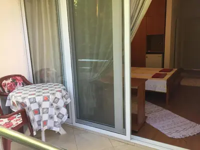 a room with a sliding glass door with a table at Tina Rooms in Ulcinj