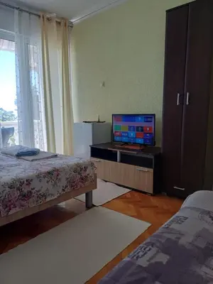 a bedroom with a bed and a television on a cabinet at Tina Rooms in Ulcinj