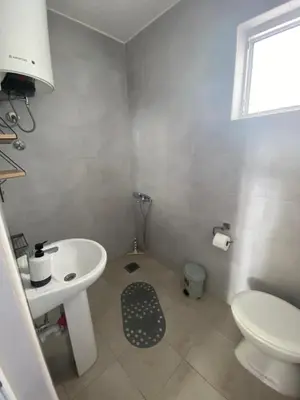 a white bathroom with a sink and a toilet at Apartment Tijana in Bar